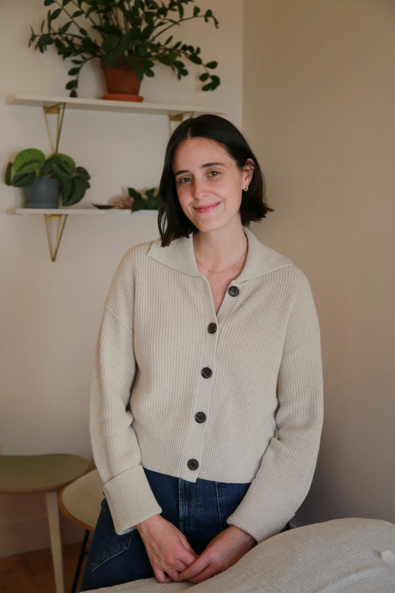 Kyla smiling in a beige cardigan in a treatment room